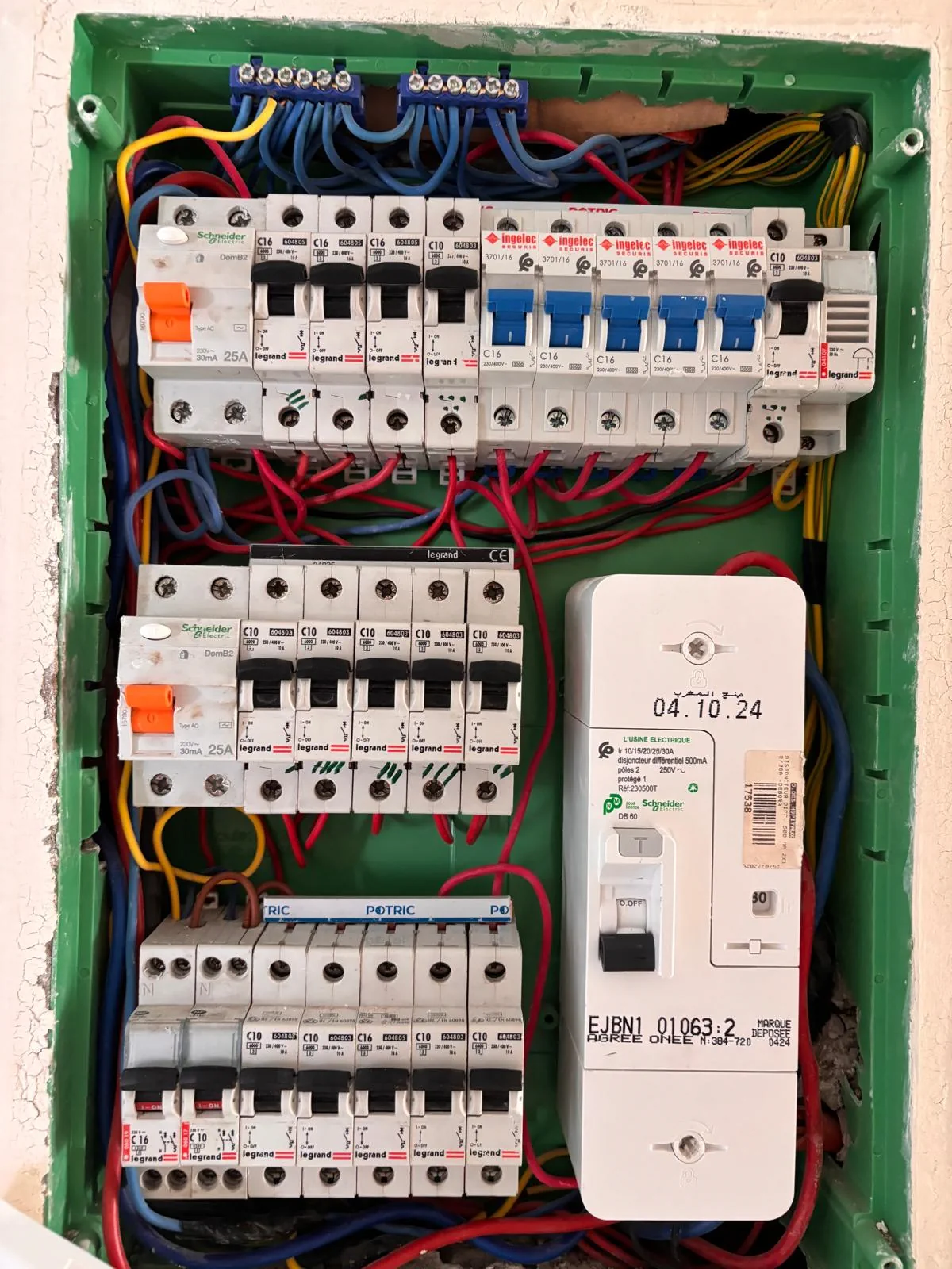 Tableau électrique ouvert montrant disjoncteurs, protections différentielles et câblage.